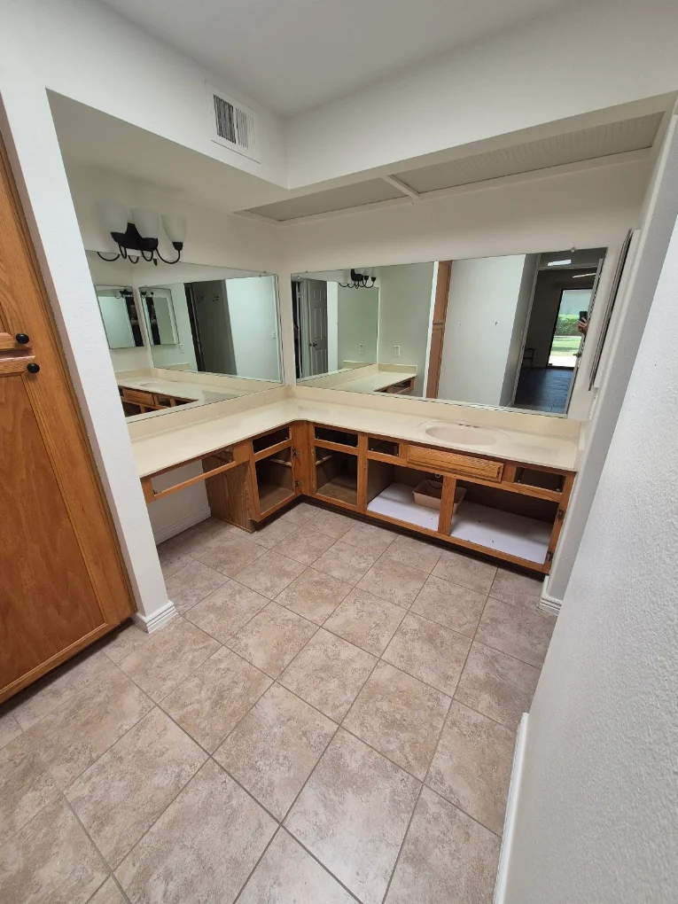 Existing bathroom vanity with oak cabinets and beige tile before remodeling