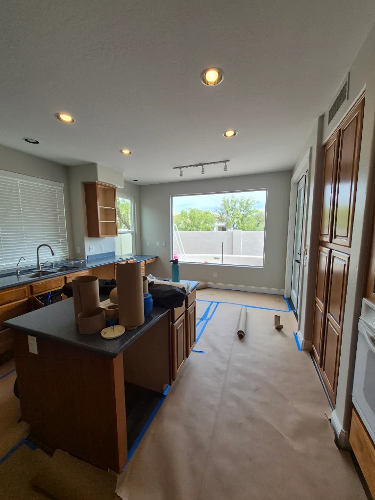 Kitchen mid-remodel with floors protected by protective covering during work
