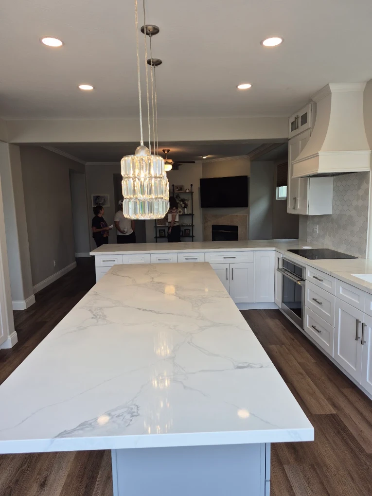 Completed kitchen with white shaker cabinets, a quartz island, and a hexagon tile backsplash