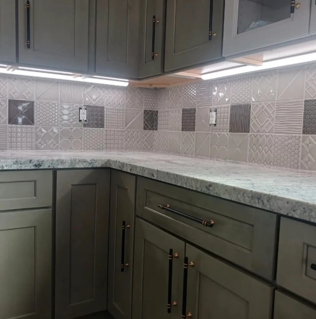 Kitchen with slate-gray cabinets, speckled granite counters, and under-cabinet lighting