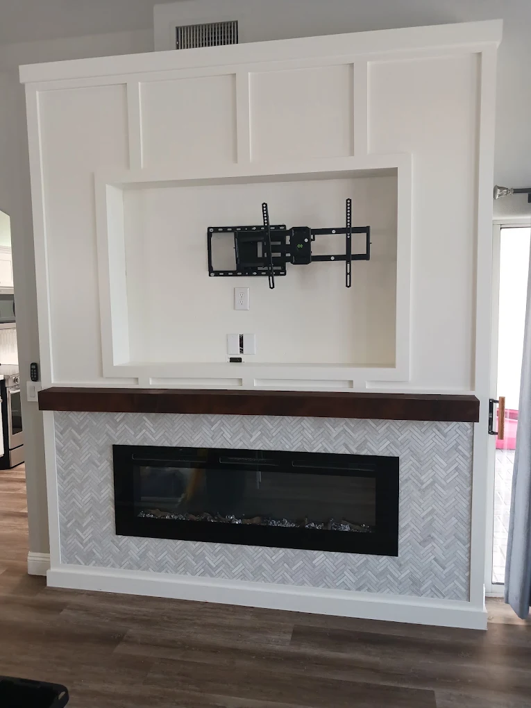 Living room with a board-and-batten fireplace wall, herringbone tile surround, and wood mantel