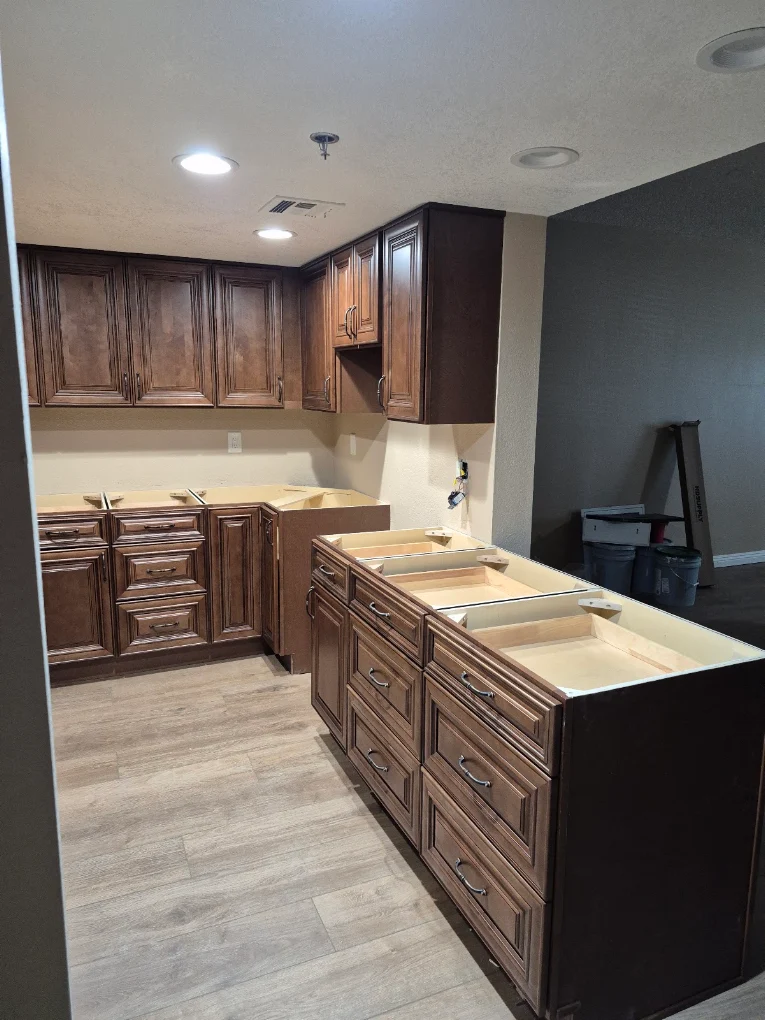 Dark wood cabinets installed in a kitchen under renovation
